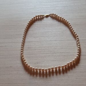 Beautiful faux pearl single strand necklace. Knotted between each pearl.